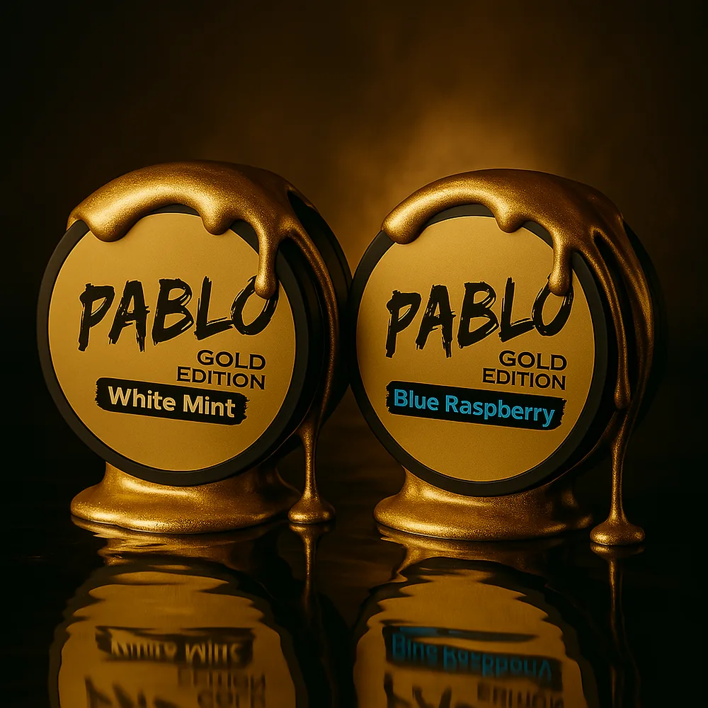Pablo Gold Edition White Mint and Blue Raspberry cans dripping with molten gold on a dark reflective surface