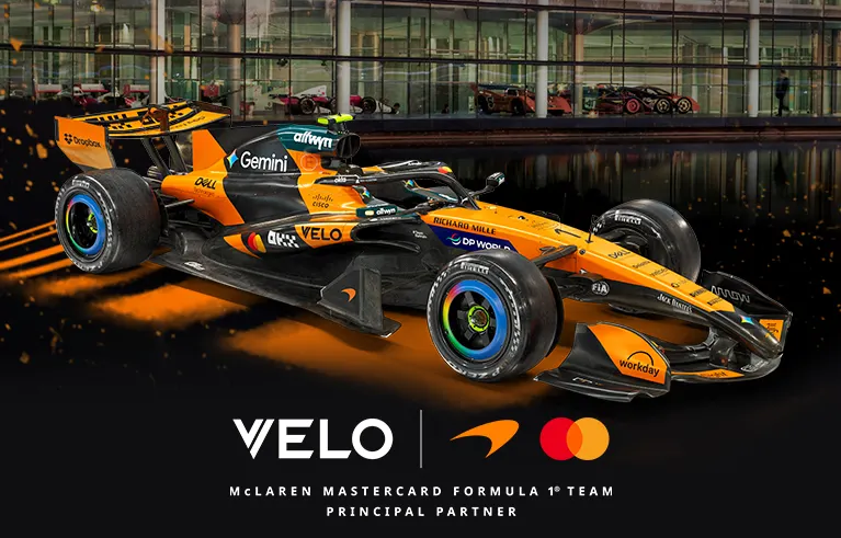Official VELO banner showing the McLaren Formula 1 car carrying VELO branding as principal partner