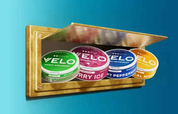 Official VELO campaign banner showing slim nicotine pouch cans in a letterbox, including Bright Spearmint, Cherry Ice, Crispy Peppermint and Tropical Mango